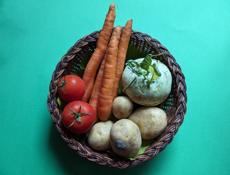 Ein Körbchen mit frischem Gemüse: Möhren, Kohlrabi, Tomate und Kartoffeln