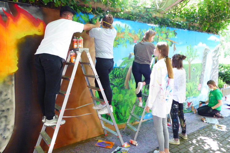 Das Foto zeigt Schüler*innen bei einem Graffiti-Workshop zum Thema 