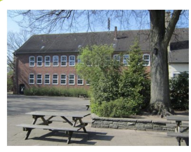 Das Foto zeigt unsere Schule mit Teilen des Schulhofes