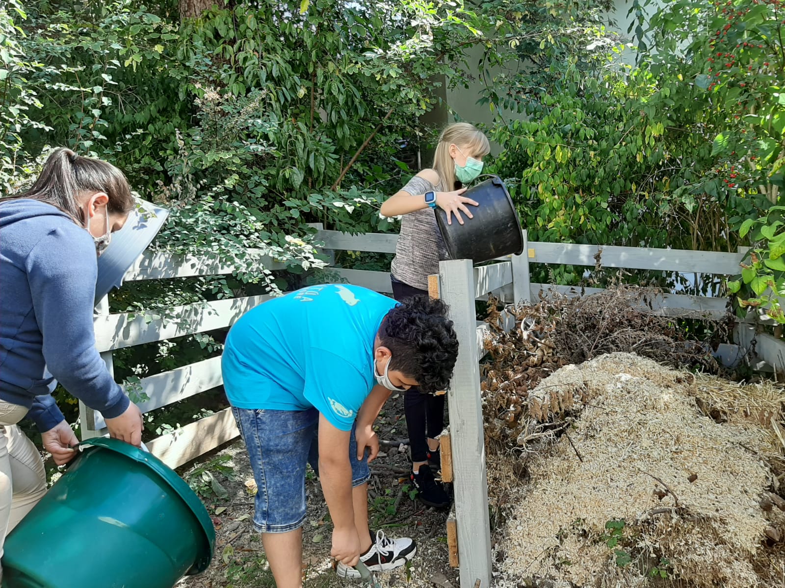 Schülerinnen und Schüler arbeiten am Kompost