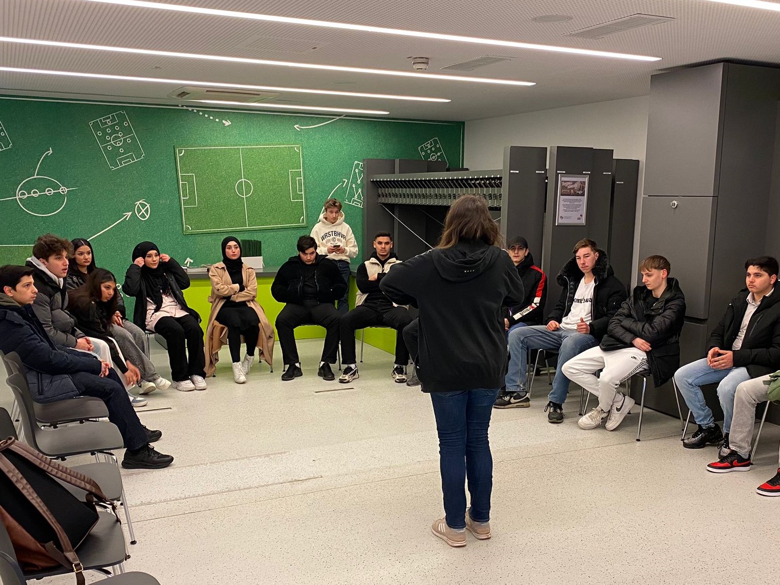 Schüler:innen sitzen im Stuhlkreis im Seminarraum des Fußballmuseums
