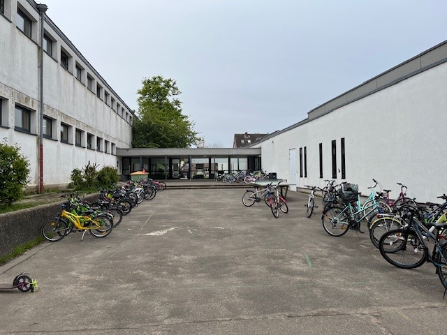 Auf dem Schulhof stehen ganz viele bunte Fahrräder 