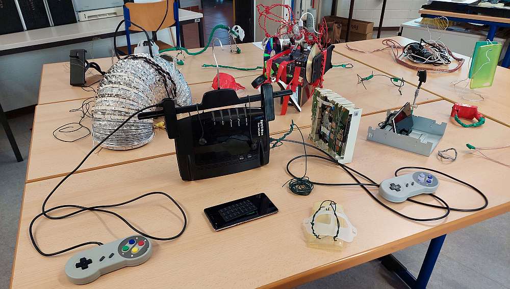 Das Bild zeigt verschiedene elektrische bzw. elektronische Geräte wie ein Handy und ein Radio zum Reparieren auf einem Tisch. 