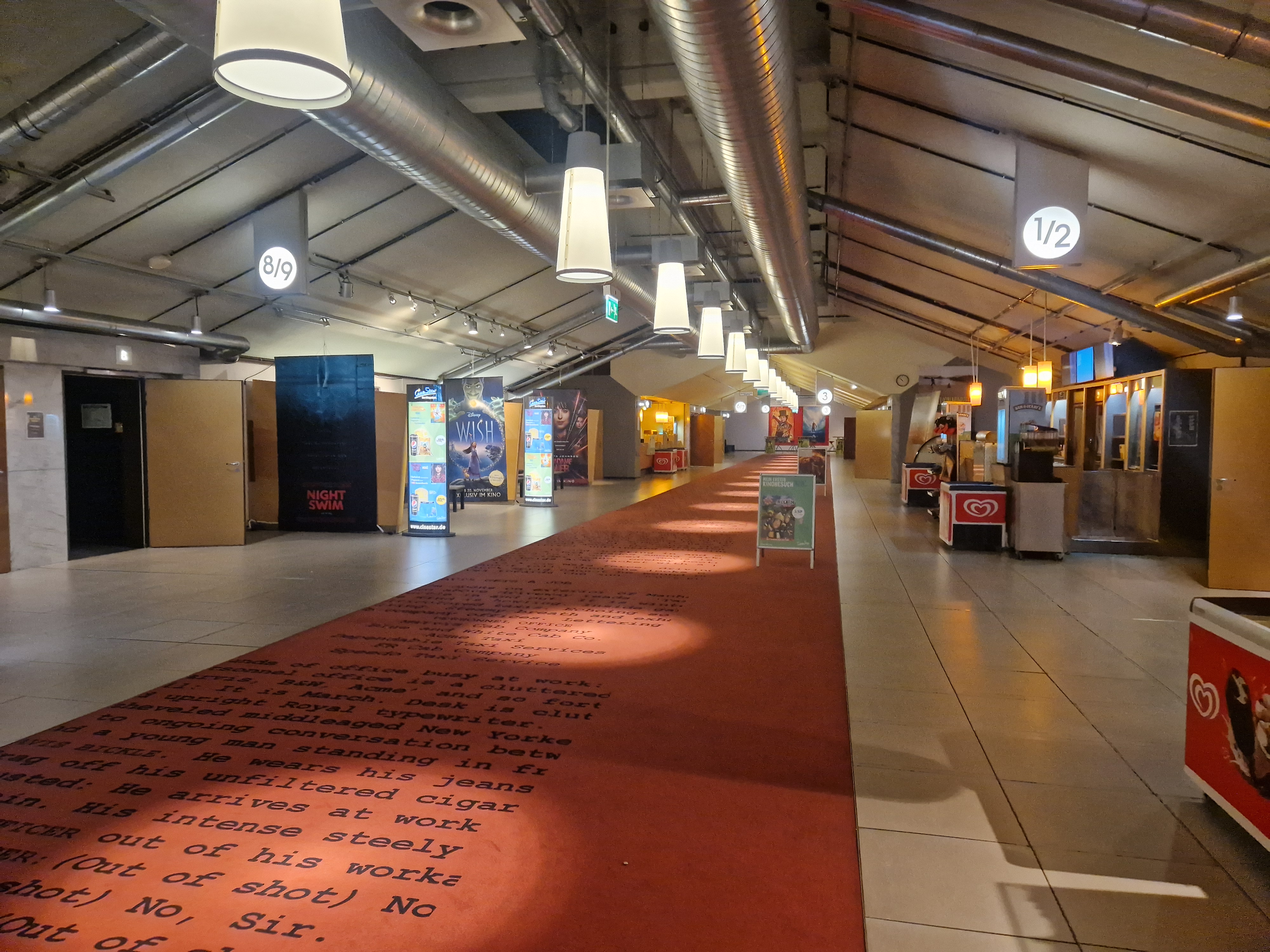 Das Bild zeigt den weitläufigen Eingangsbereichs eines Düsseldorfer Kinos mit Plakaten zu den verschiedenen Filmangeboten in den Schulkinowochen NRW. 