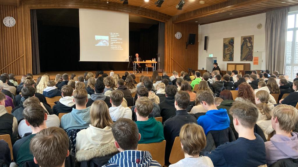 Holocaust-Zeitzeuge Bert Woudstra berichtet auf der Bühne in der Aula der Euregio Gesamtschule Rheine vor SchülerInnen der Jahrgänge 10-13